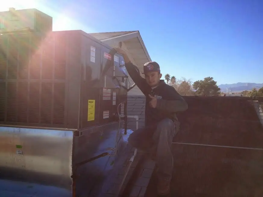HVAC technician performing Boiler Repair on a rooftop unit in Nibley